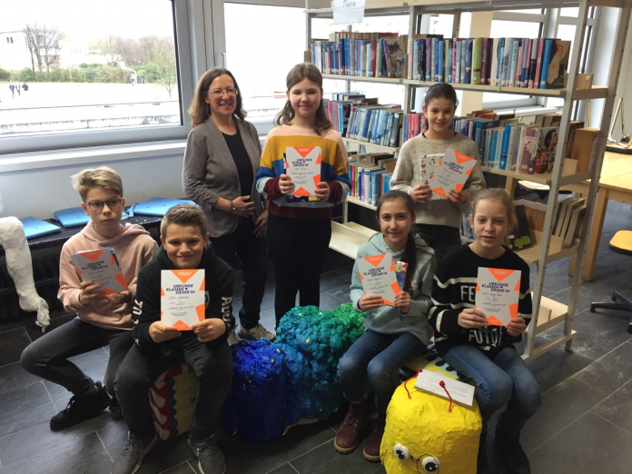 02_WUE_Schulsiegerin Sechs Klassensieger mit Urkunden in der Schülerbücherei, darunter Schulsiegerin Lilly Wiesner (Mitte) mit Deutschlehrerin Petra Hennecke. Foto: Städtisches Gymnasium Wülfrath