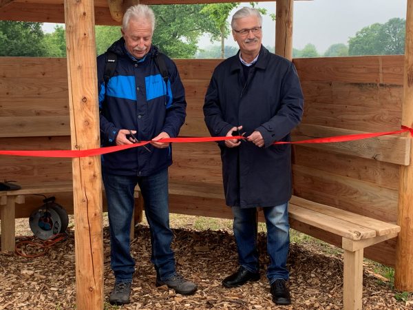 Landrat Thomas Hendele und Langenfelds stellvertretender Bürgermeister Dieter Braschoss geben die neue Wanderschutzhütte frei. Foto: Kreis ME