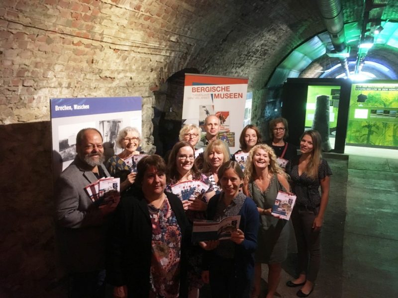 37_WUE_AK Bergische Museen Vertreterinnen und Vertreter der Bergischen Museen sowie die Geschäftsstelle des Arbeitskreises präsentieren im Zeittunnel Wülfrath Broschüre und Flyer des Themenjahres „Ganz viel Arbeit“, die ab sofort in allen teilnehmenden Museen und an vielen weiteren Stellen ausliegen. Foto: Arbeitskreis Bergische Museen